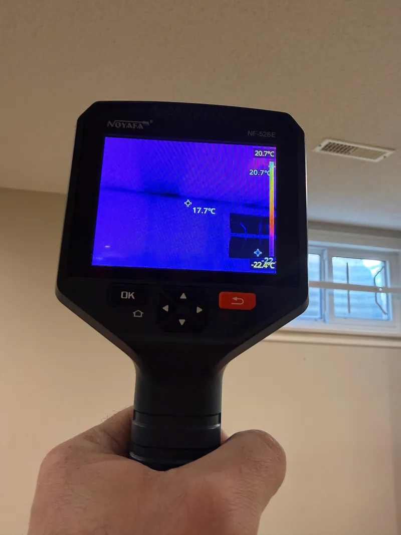 Thermal imaging camera showing a cold spot indicating hidden moisture in a drywall